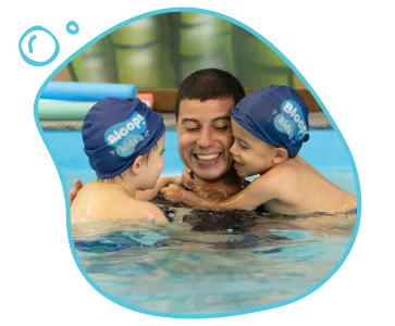 Pai com seus dois filhos na escola de natação