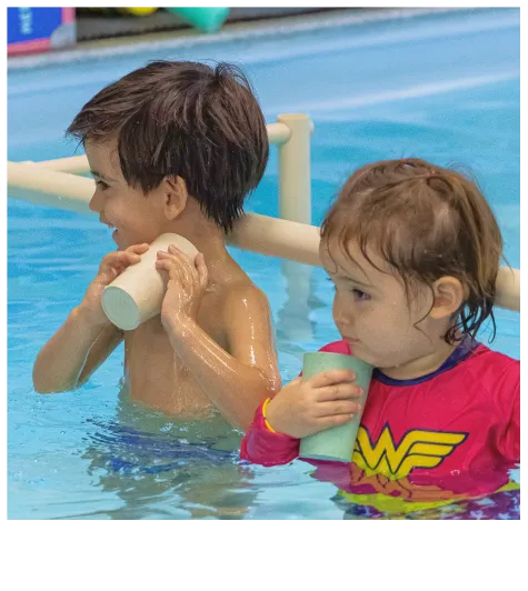 Duas crianças na aula de natação com um copo na mão