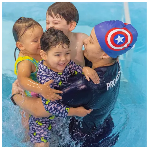 Professora de natação com touca do Capitão América na piscina com 3 crianças no color